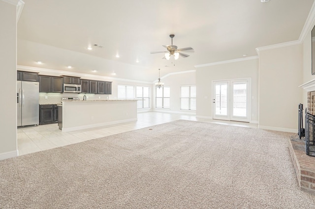 unfurnished living room featuring light tile patterned floors, light colored carpet, ornamental molding, a fireplace, and ceiling fan with notable chandelier