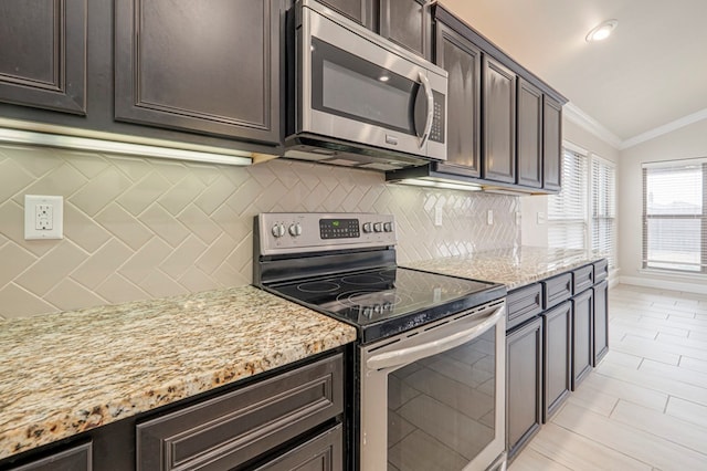 kitchen featuring ornamental molding, appliances with stainless steel finishes, dark brown cabinetry, and light stone countertops