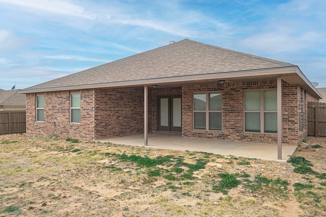 back of house featuring a patio, brick siding, a shingled roof, and fence