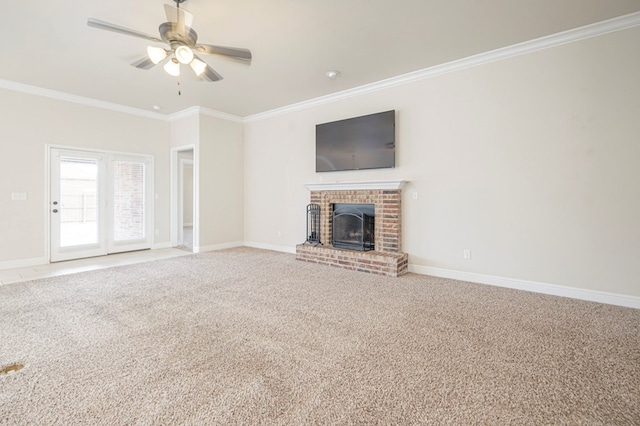 unfurnished living room with carpet, a brick fireplace, crown molding, and baseboards