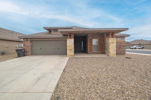 view of front of property featuring a garage, driveway, and brick siding