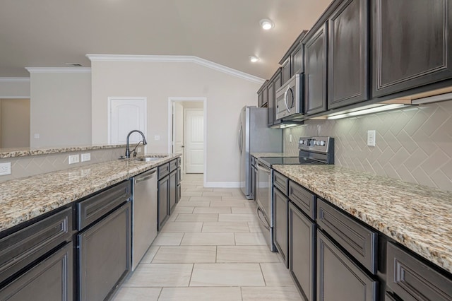 kitchen featuring dark brown cabinetry, appliances with stainless steel finishes, light stone counters, crown molding, and a sink