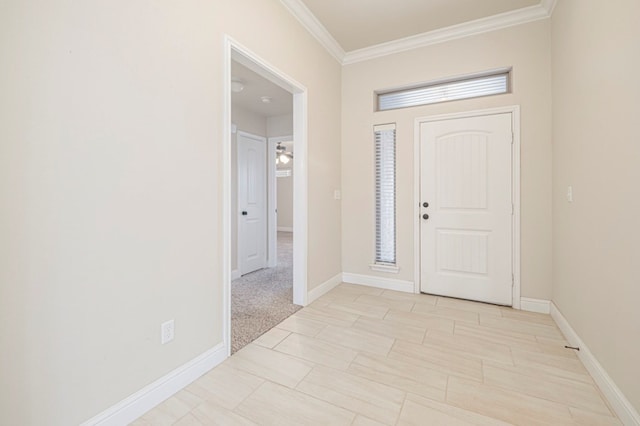 foyer entrance with crown molding and baseboards