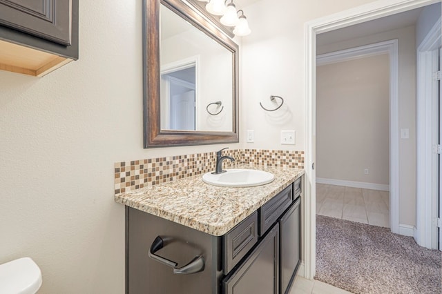 bathroom featuring baseboards, vanity, and decorative backsplash