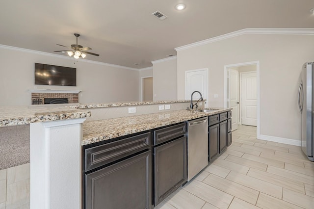 kitchen featuring a sink, visible vents, appliances with stainless steel finishes, light stone countertops, and crown molding