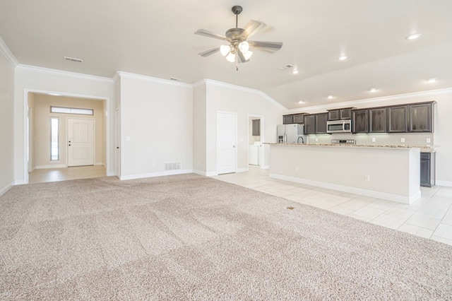 unfurnished living room featuring lofted ceiling, light carpet, crown molding, and visible vents