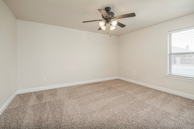 empty room featuring carpet flooring, ceiling fan, and baseboards