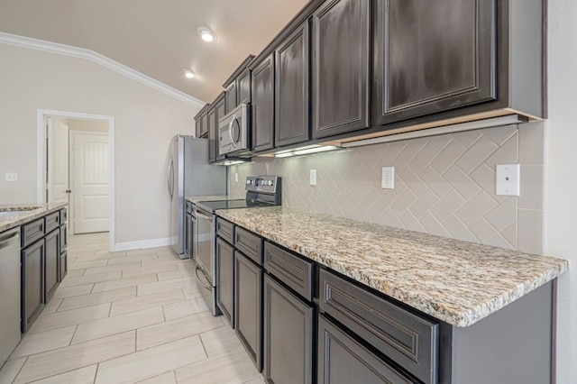 kitchen with light stone counters, decorative backsplash, appliances with stainless steel finishes, ornamental molding, and vaulted ceiling