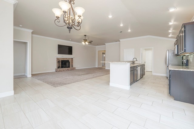 kitchen with open floor plan, decorative light fixtures, light stone countertops, a fireplace, and ceiling fan with notable chandelier