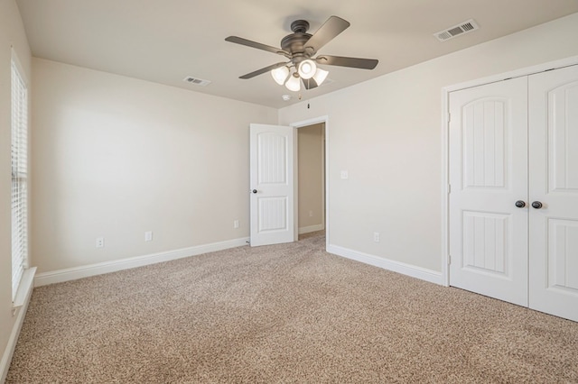 unfurnished bedroom with carpet floors, a ceiling fan, visible vents, baseboards, and a closet