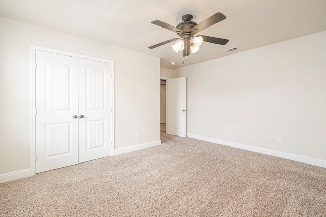 unfurnished bedroom featuring carpet floors, a closet, visible vents, and baseboards