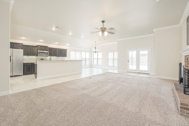 unfurnished living room with light tile patterned floors, light carpet, a ceiling fan, ornamental molding, and a brick fireplace