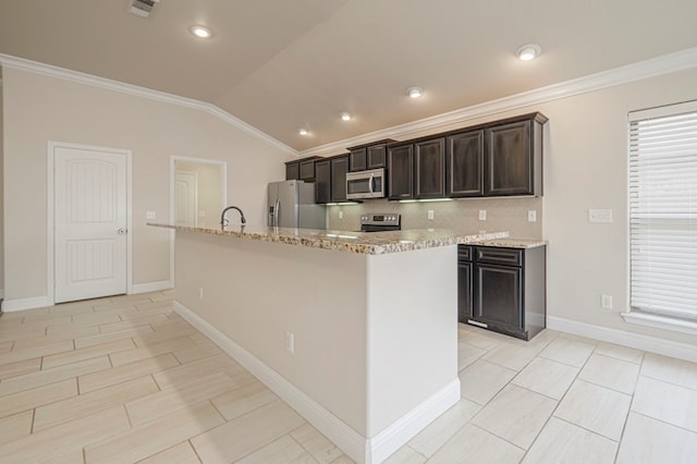 kitchen with appliances with stainless steel finishes, vaulted ceiling, crown molding, and a center island with sink