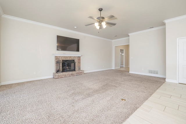 unfurnished living room with a ceiling fan, a brick fireplace, visible vents, and crown molding