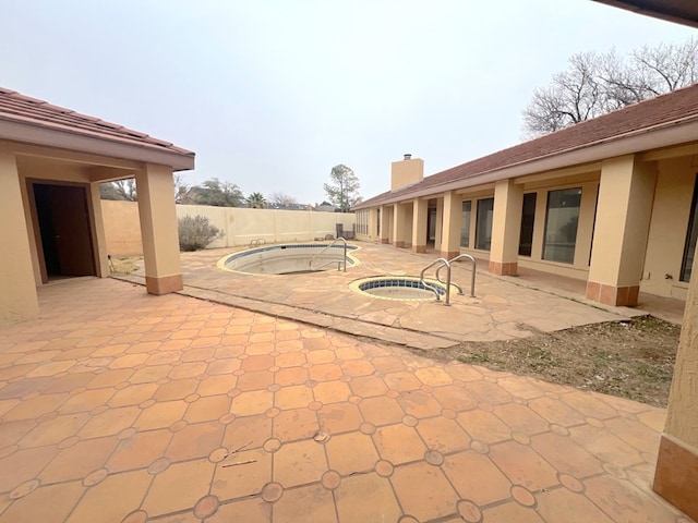 view of patio / terrace with an in ground hot tub