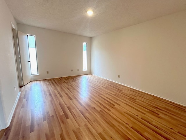 spare room with light hardwood / wood-style flooring and a textured ceiling