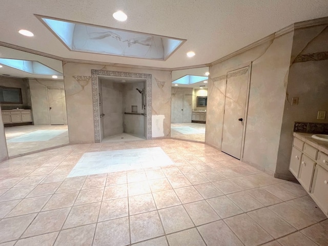 bathroom with a shower, tile patterned floors, a textured ceiling, vanity, and crown molding