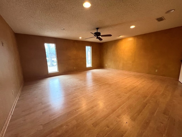 empty room featuring ceiling fan, light hardwood / wood-style floors, and a textured ceiling