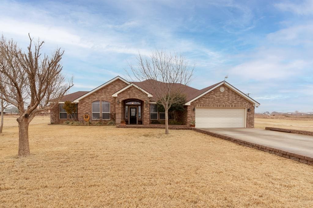 view of front of property featuring a front lawn and a garage