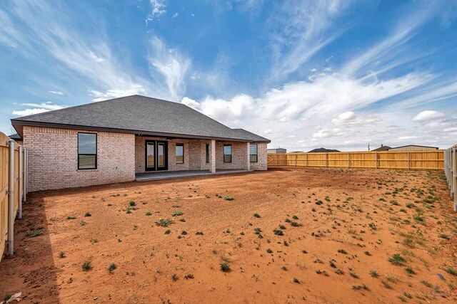 2102 S County Rd 1059, Midland, TX 79706 - rear view of property featuring brick siding, roof with shingles, a fenced backyard, and a patio area