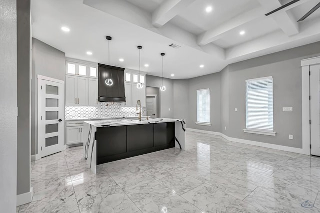 2102 S County Rd 1059, Midland, TX 79706 - kitchen featuring visible vents, baseboards, backsplash, light countertops, and an island with sink