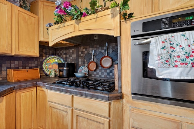 3811 Cimmaron Ave, Midland, TX 79707 - kitchen with oven, tile countertops, black gas cooktop, and tasteful backsplash