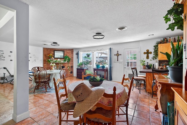 3811 Cimmaron Ave, Midland, TX 79707 - dining room featuring a textured ceiling, a brick fireplace, baseboards, and light tile patterned floors