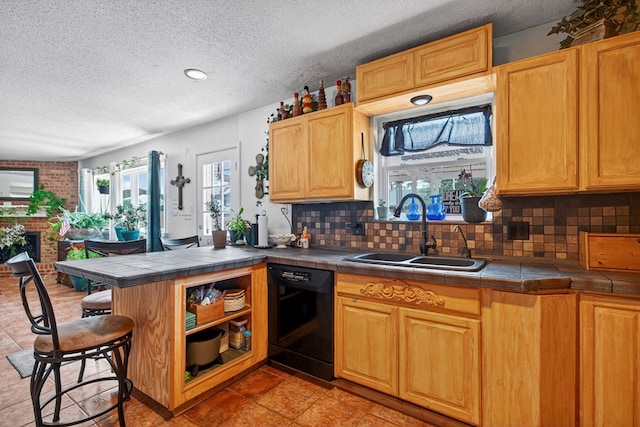 3811 Cimmaron Ave, Midland, TX 79707 - kitchen featuring black dishwasher, a sink, tile countertops, tasteful backsplash, and a textured ceiling