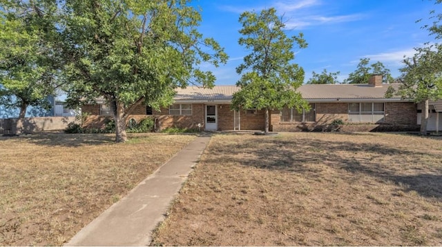 single story home featuring brick siding and a front yard