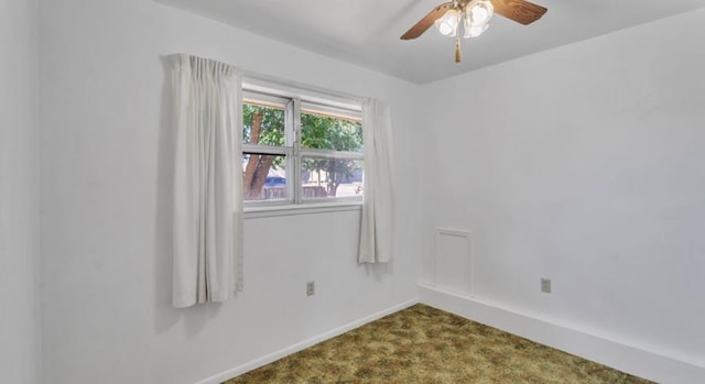 spare room with dark carpet, baseboards, and ceiling fan