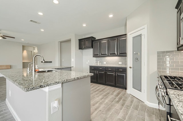 6913 Mcpherson Ln, Midland, TX 79706 - kitchen featuring a sink, light wood-style floors, tasteful backsplash, and recessed lighting