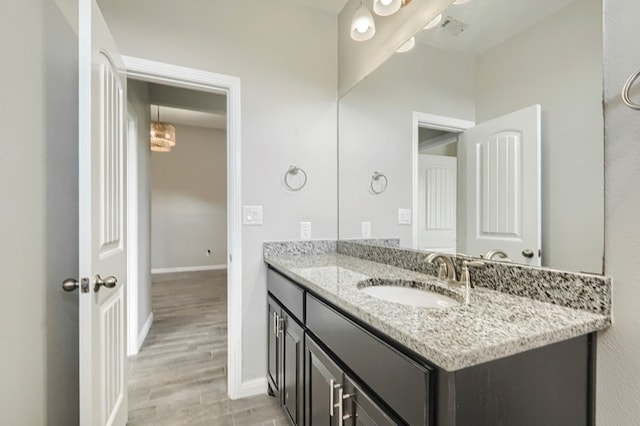 6913 Mcpherson Ln, Midland, TX 79706 - bathroom featuring vanity, baseboards, and wood finished floors