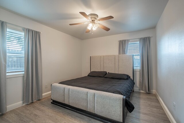 bedroom featuring baseboards, ceiling fan, and wood finished floors