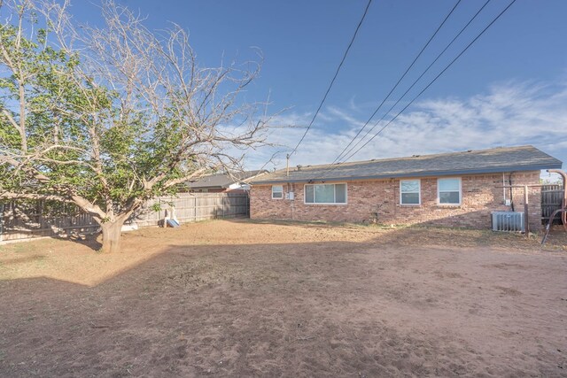 back of house with fence and brick siding