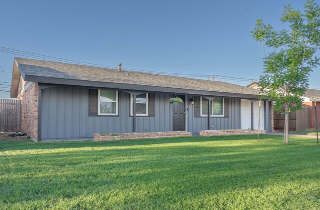 ranch-style home with board and batten siding, fence, and a front lawn