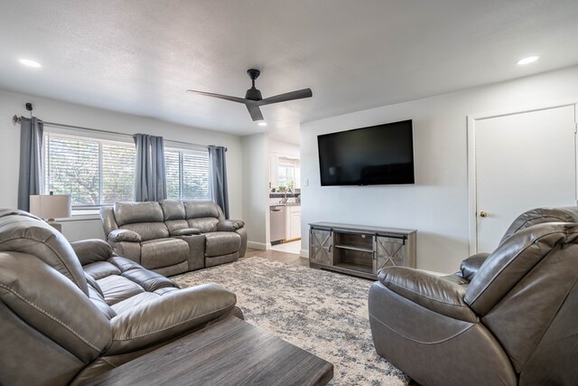 living room featuring a ceiling fan, baseboards, recessed lighting, and wood finished floors