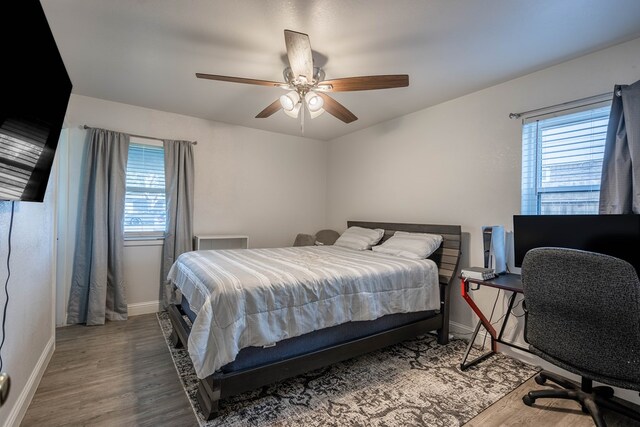 bedroom featuring baseboards, ceiling fan, and wood finished floors