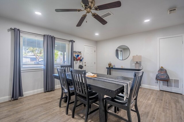 dining room featuring baseboards, light wood-style flooring, ceiling fan, and visible vents