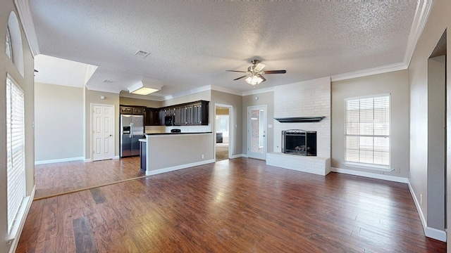 3304 Claremont Dr, Midland, TX 79707 - unfurnished living room with a ceiling fan, dark wood-style floors, a textured ceiling, a fireplace, and baseboards