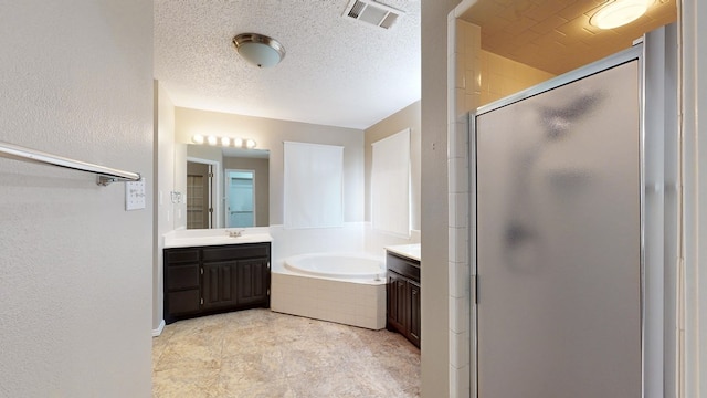 3304 Claremont Dr, Midland, TX 79707 - bathroom featuring vanity, a shower stall, a bath, and a textured ceiling