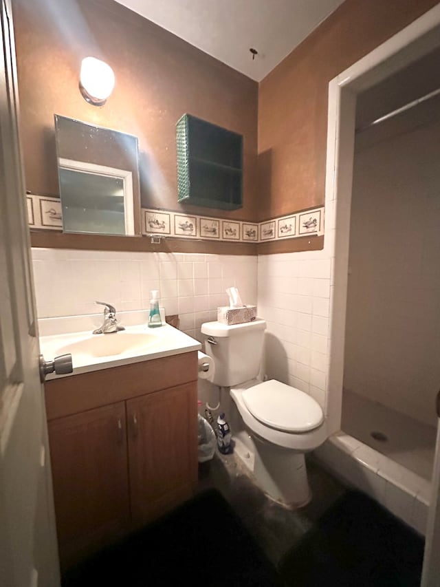 bathroom with walk in shower, vanity, toilet, and tile walls