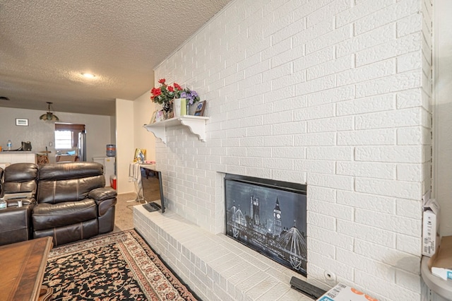 carpeted living room with a brick fireplace and a textured ceiling