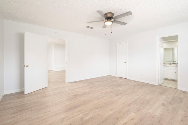 unfurnished bedroom with ceiling fan, light hardwood / wood-style floors, a textured ceiling, and ensuite bathroom