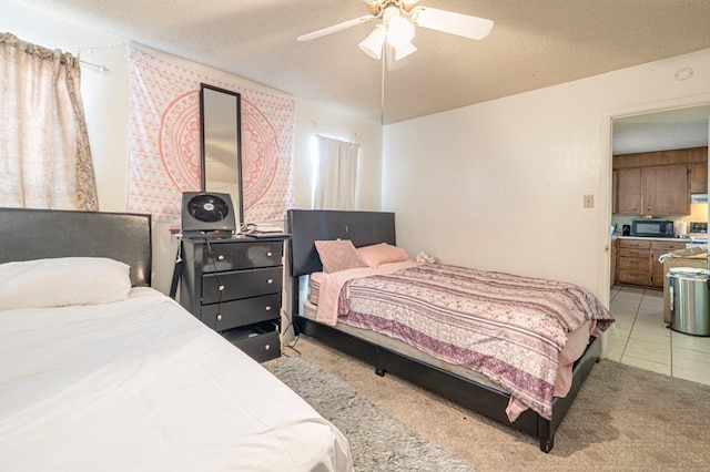 tiled bedroom with ceiling fan and a textured ceiling