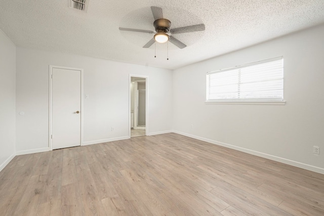 spare room with ceiling fan, a textured ceiling, and light wood-type flooring