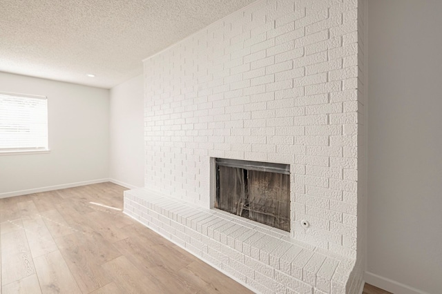 interior details featuring wood-type flooring, a textured ceiling, and a fireplace