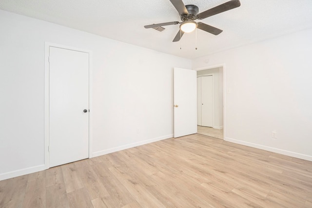 spare room featuring ceiling fan, a textured ceiling, and light wood-type flooring