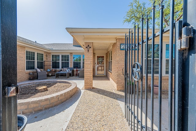 exterior space featuring brick siding, a patio, and an outdoor hangout area