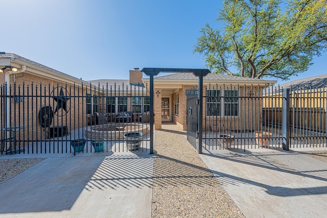 view of front facade featuring a patio area, fence, and a gate