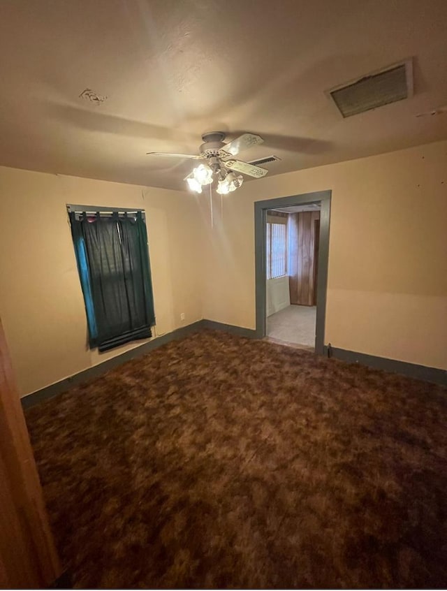 carpeted spare room featuring ceiling fan